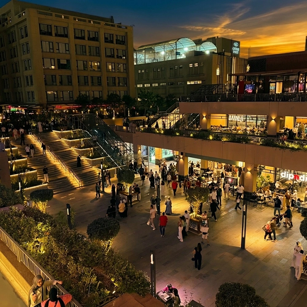 Night view of Arkan Plaza in Sheikh Zayed, Egypt, a premier luxury destination for Dina Elite medical tourism and concierge clients from Saudi Arabia, United Arab Emirates, Qatar, Kuwait, Bahrain, Oman, Jordan, Iraq, Lebanon, Libya, Palestine, Yemen, Syria, Sudan, Morocco, Algeria, Tunisia, Mauritania, Djibouti, Somalia, and Comoros, featuring high end dining and entertainment 