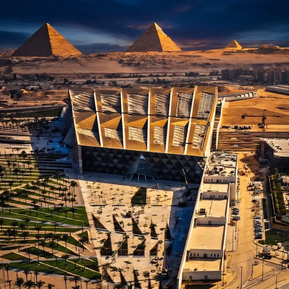 "منظر بانورامي يجمع بين عظمة الأهرامات وهندسة المتحف المصري الكبير الحديثة، يمثل وجهة السياحة الفاخرة في مصر 2026 لعملاء دينا إيليت "